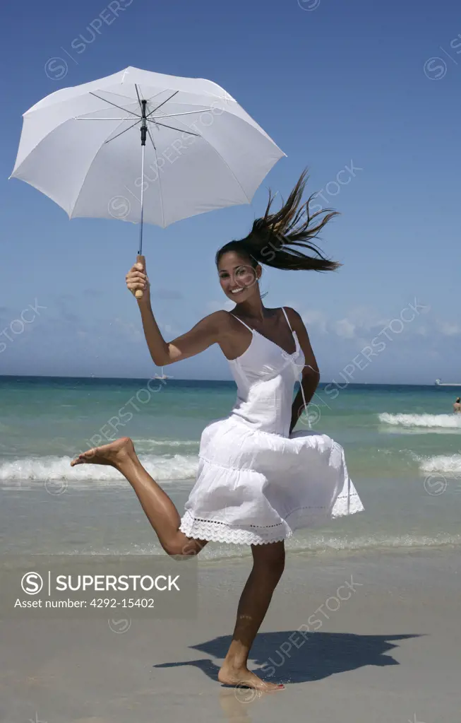 Woman standing on beach with parasol