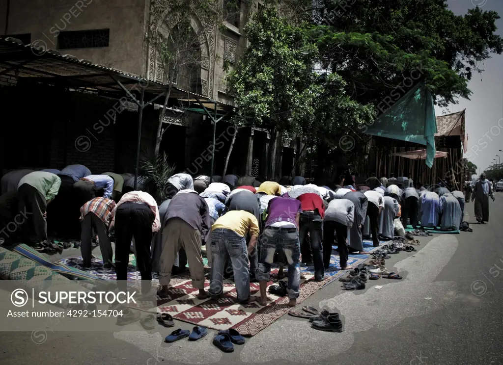 Egypt, Cairo, Market of El Mokatan close Muqattan Hill. Men in preyer on the road.