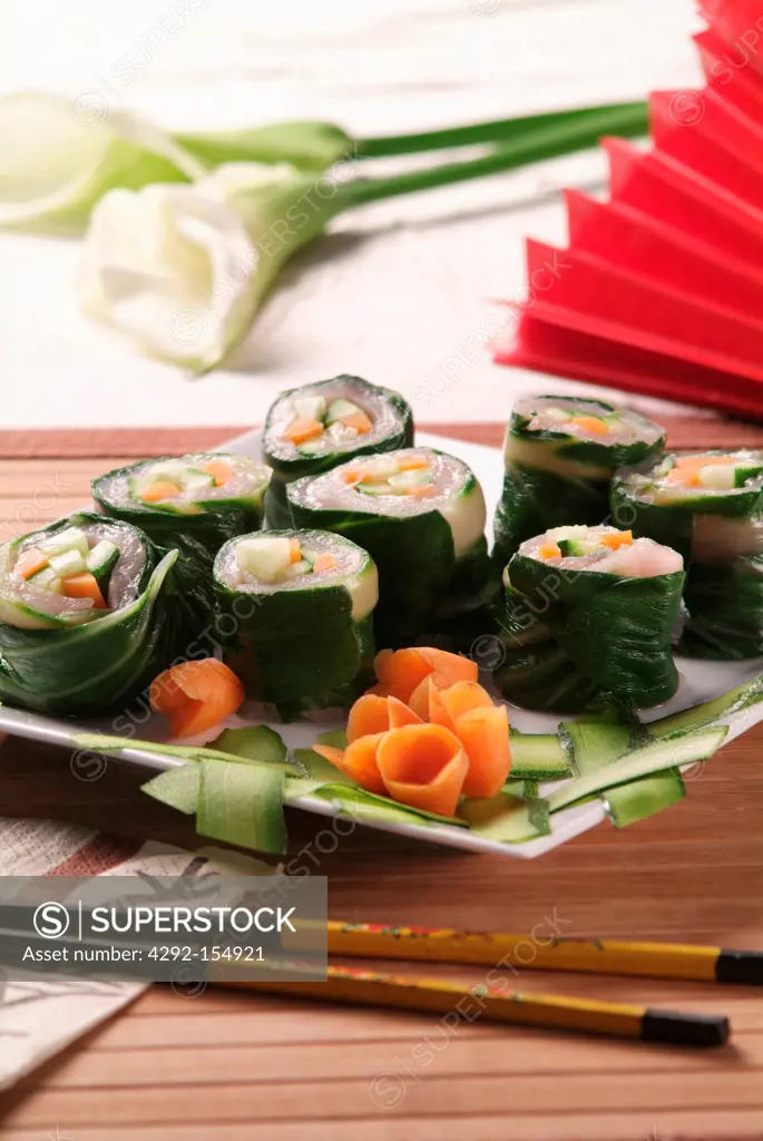Pieces of bass sushi wrapped in spinach leaves and filled with little cubes of courgette, cucumber and carrots