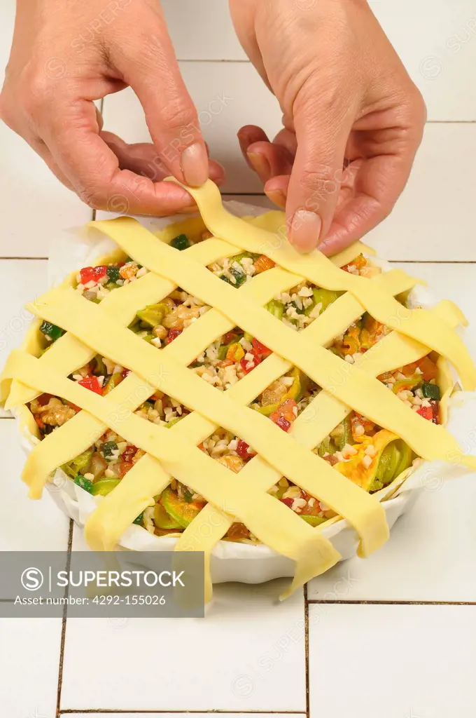 Decorating a tart with puff-pastry stripes before baking