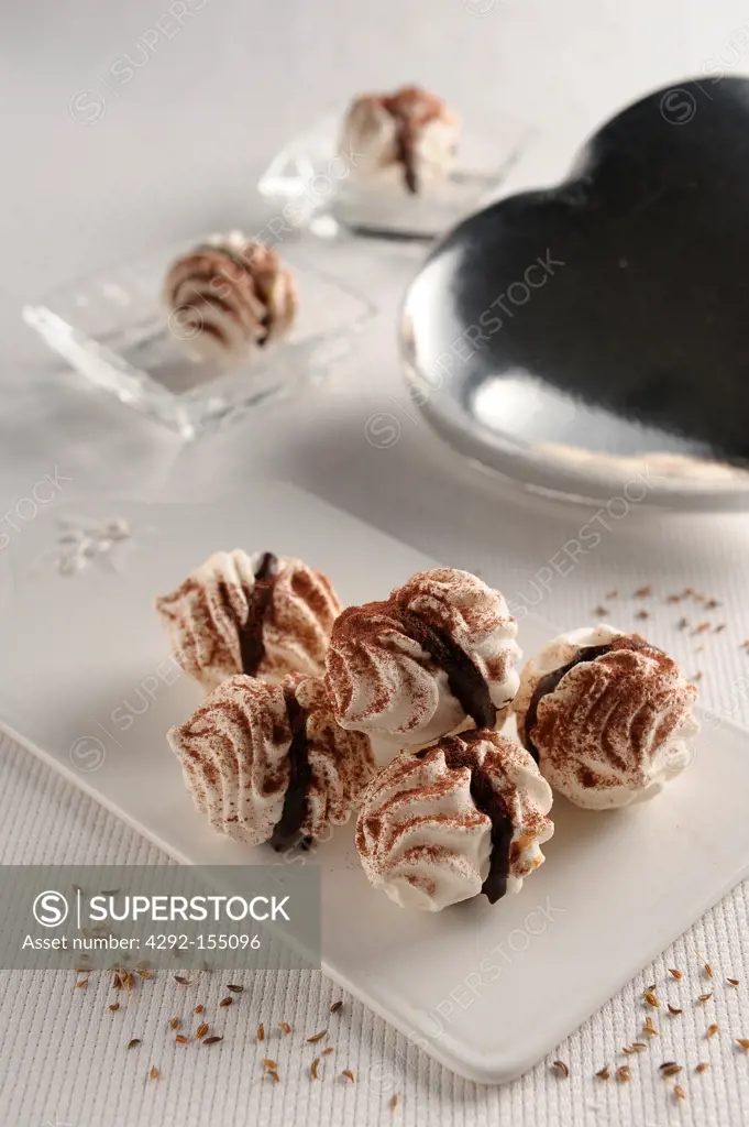 Little meringues being filled with chocolate cream