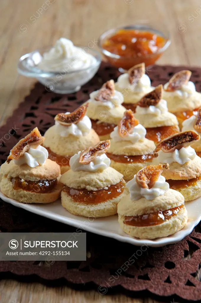 Scones filled with fig jam and decorated with whipped cream