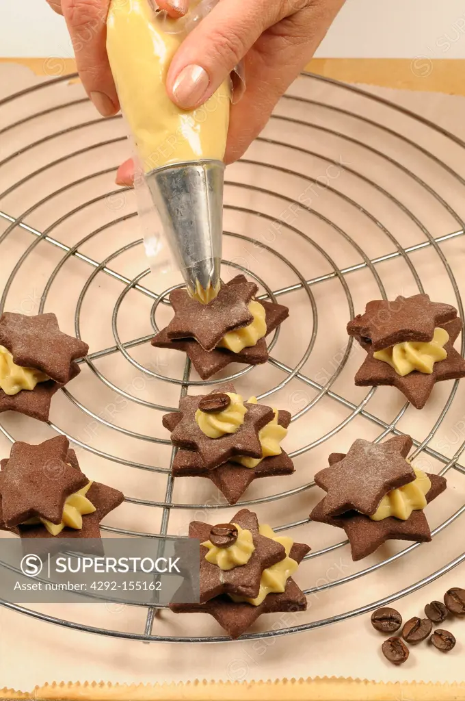 Star shaped biscuits filled with cream being decorated