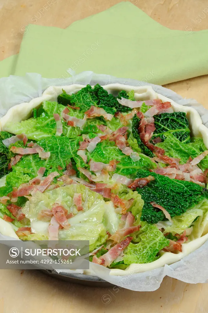 Tart filled with savoy cabbage and bacon before baking
