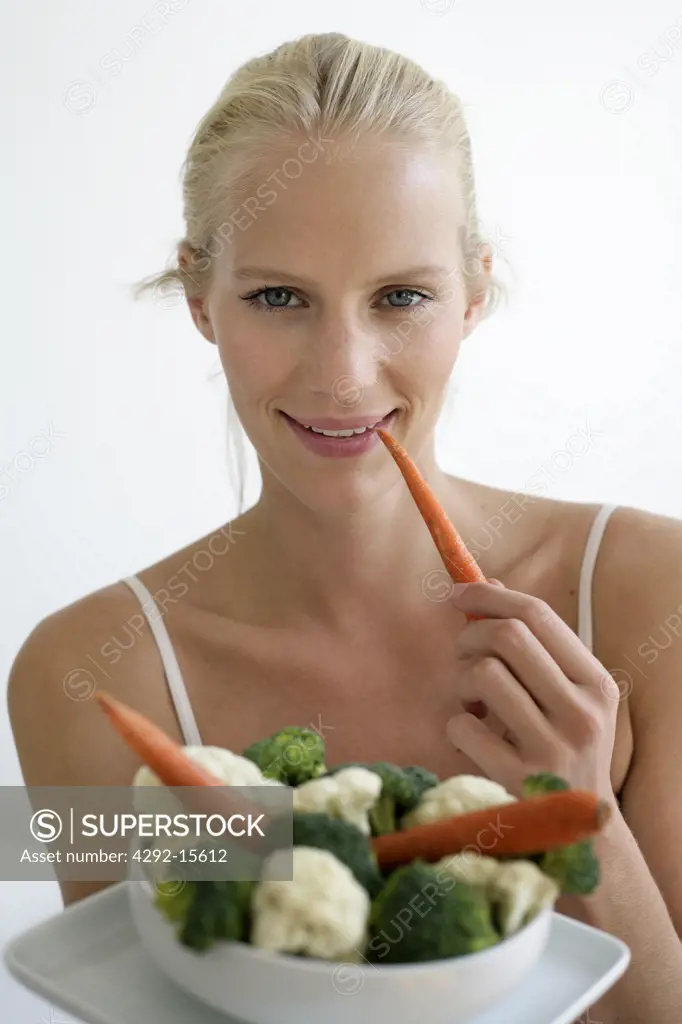 Portrait of woman holding a bowl of mixed vegetables