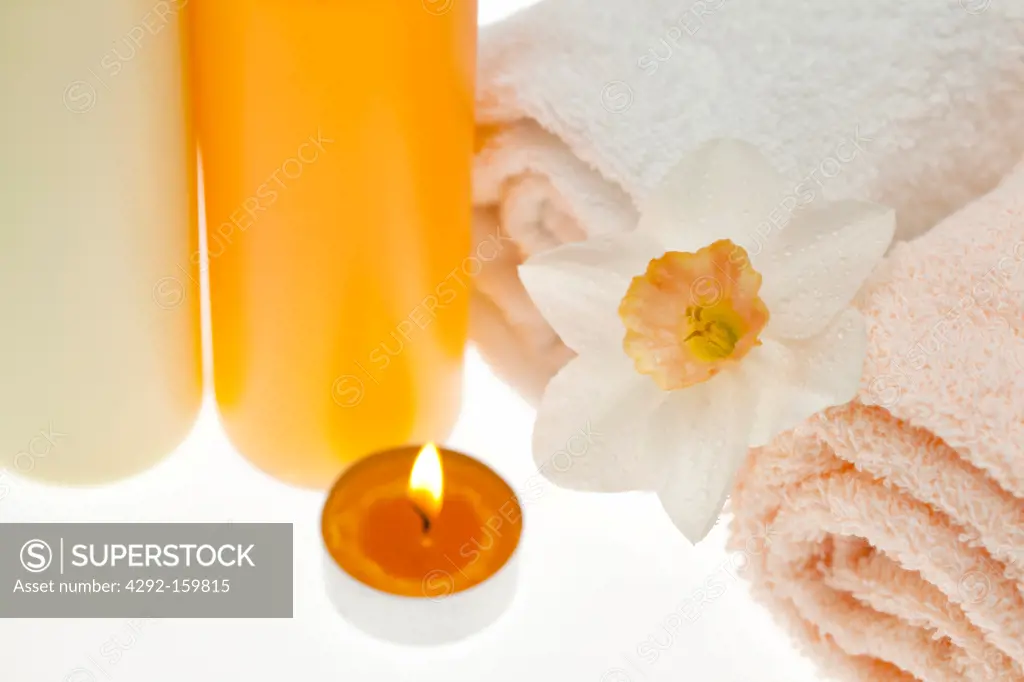 spa elements, soap, body cream, grey stones, candle and flower
