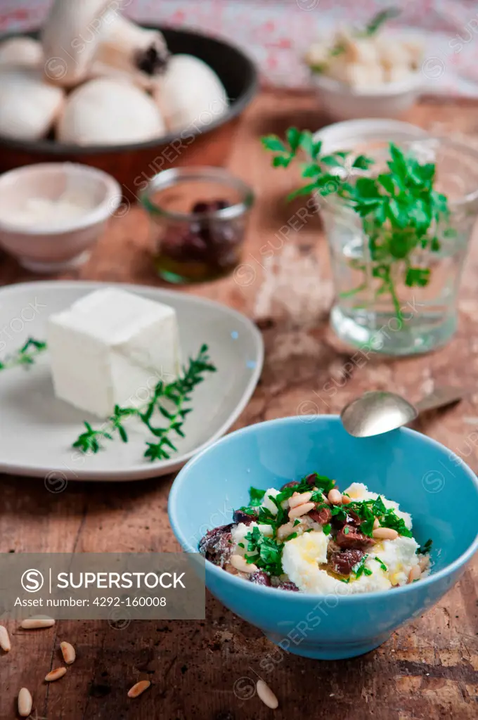 soft cheese in a cup with ingredients and fresh herbs
