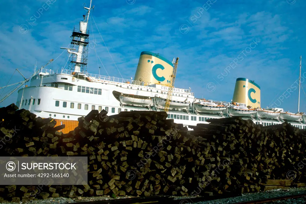 Italy, Liguria, Genoa harbour, cruise ship behind heap of coal of the power station