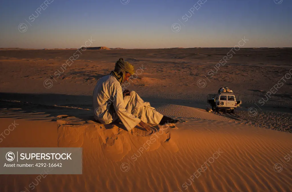 Algeria, Sahara, Erg Chech Desert, man sitting on dune