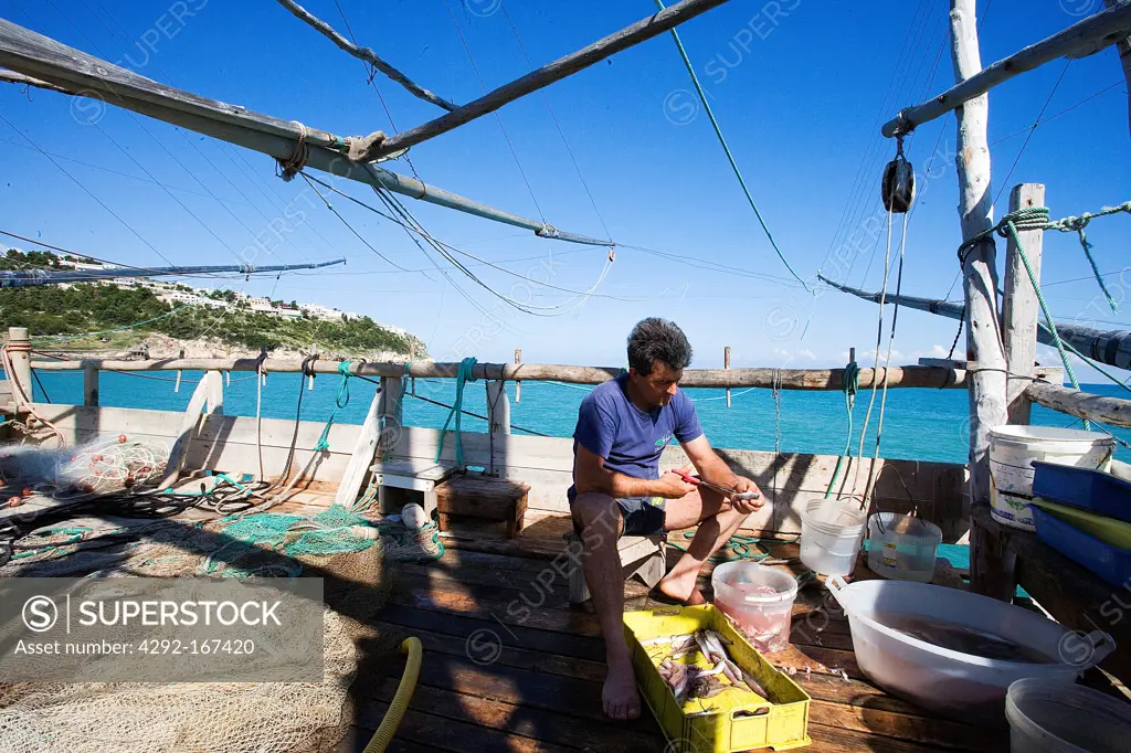 Italy, Apulia, Gargano, fisherman on trabucco