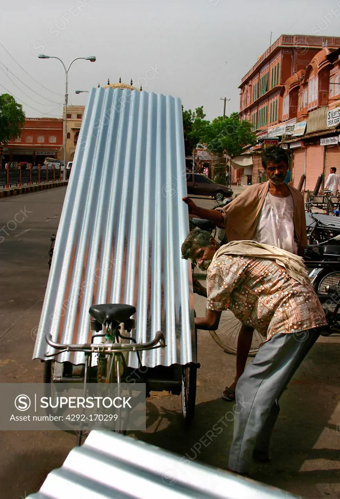 India, Delhi, man with loading bicycle