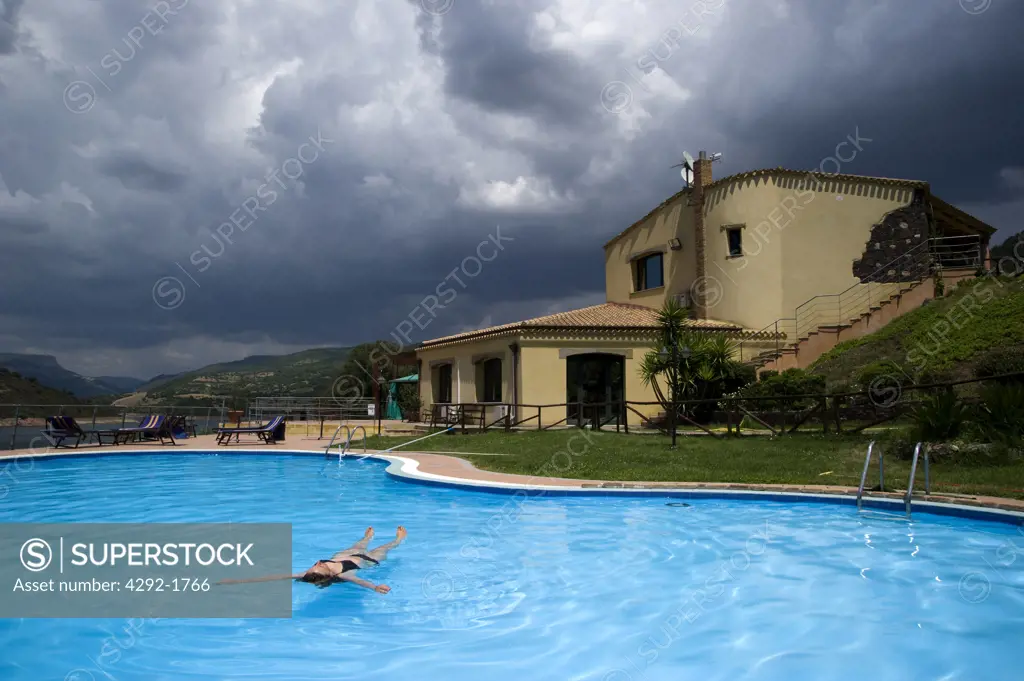 Italy, Sardinia, woman in swimmingpool