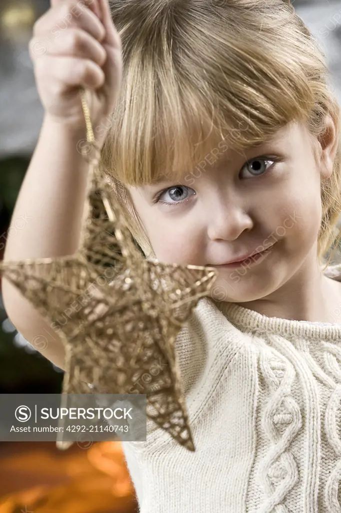 girl holding a Christmas star