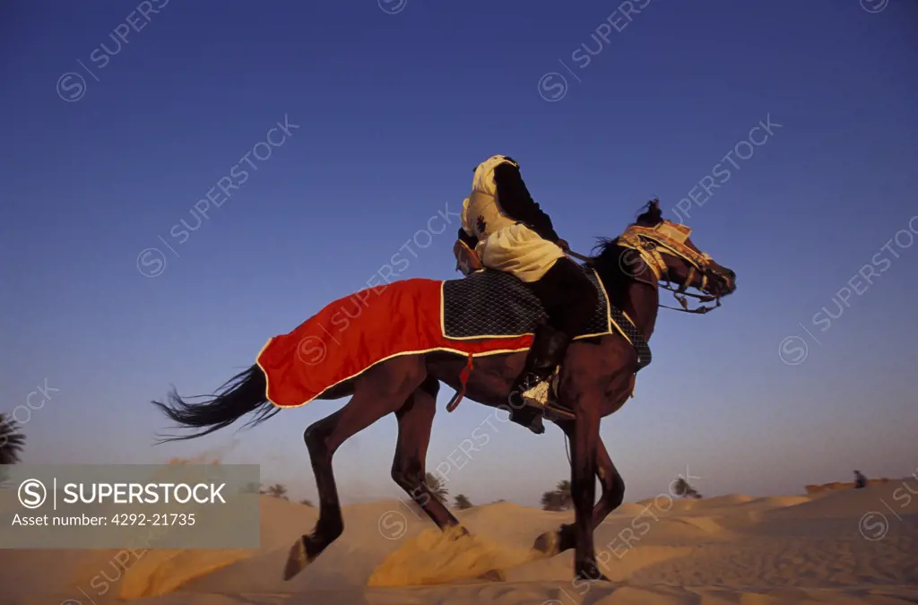 Tunisia, Berber raider running on the dunes of Zafrane