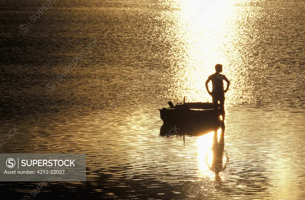 Man with boat at sunset