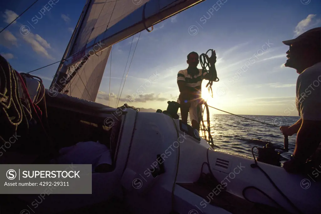 Sailboat crew in action at dusk