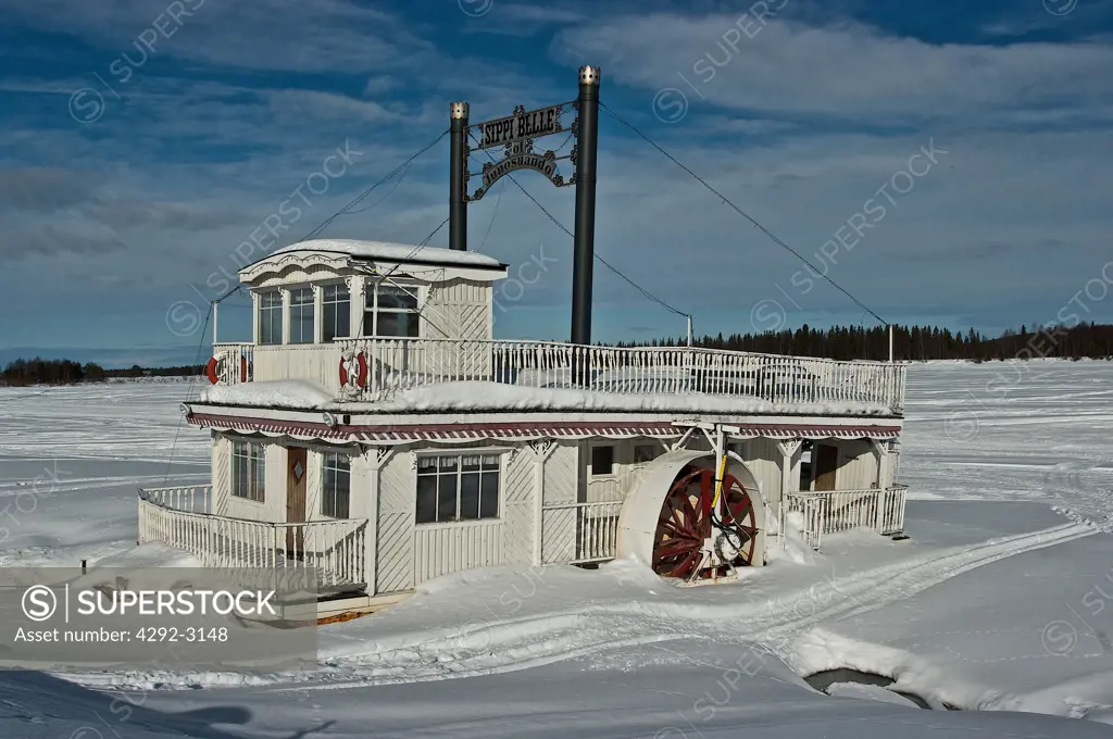 Europe, Sweden, Lapland, Sippi Belle river paddle boat moored in ice and snow