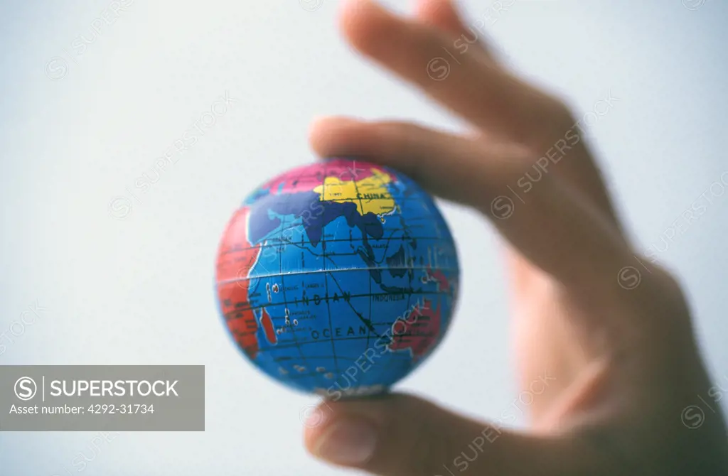 Hand holding small globe