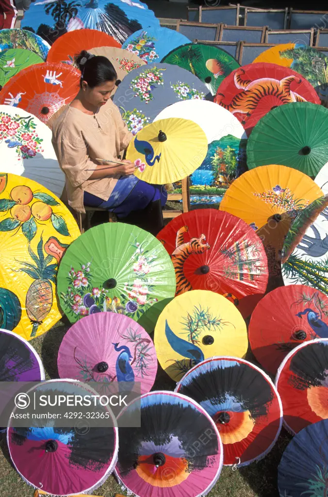 Thailand, Chiang Mai. Sa Paper umbrella factory. Woman painting umbrella