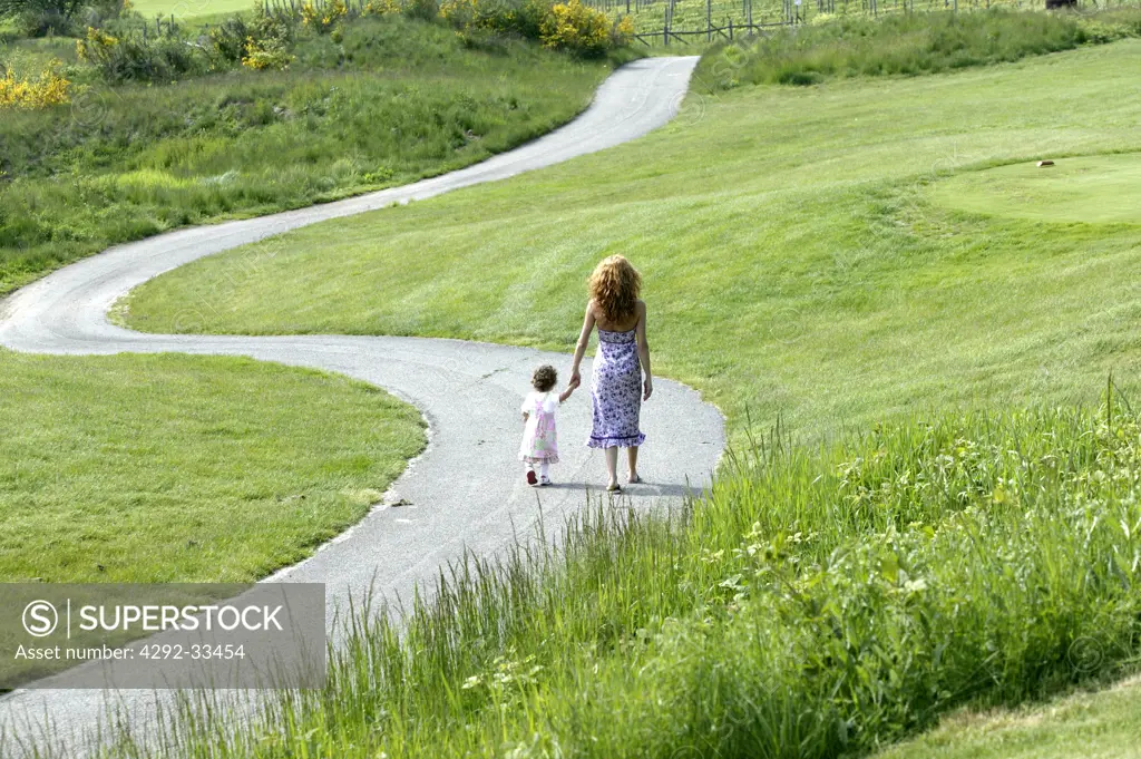 Mother and daughter walking on a country road
