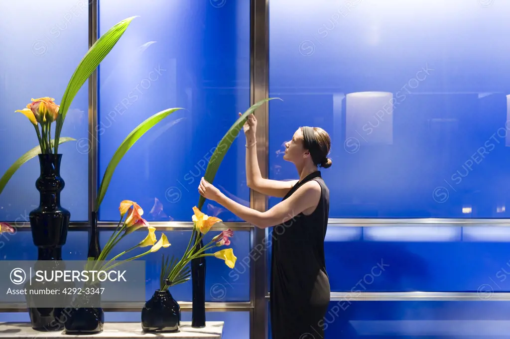 England, London, waiter arranging fresh flowers in the Hakkasan restaurant