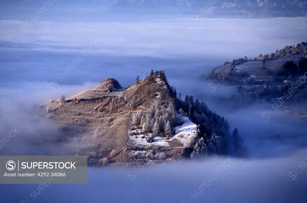 Switzerland, Hills in the fog near Sierre