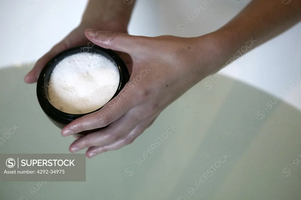 Woman holding bowl with bath salt