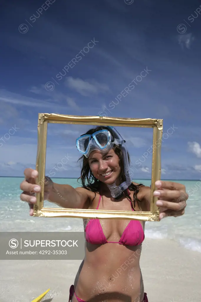 Woman's portrait at sea holding an empty frame