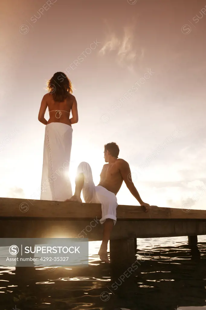 Couple on pier at sunset, Maldives