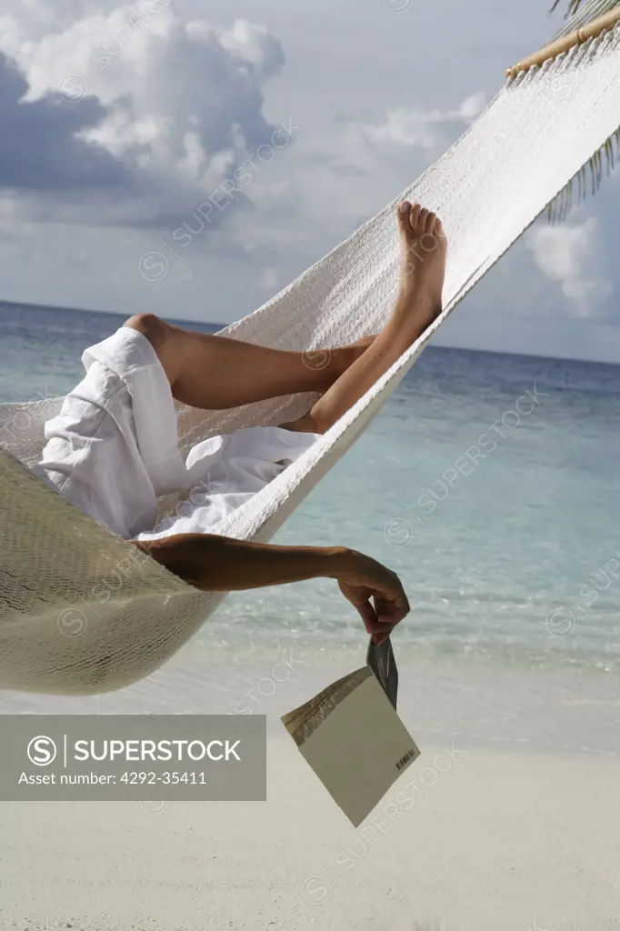 Woman in hammock holding a book, legs detail
