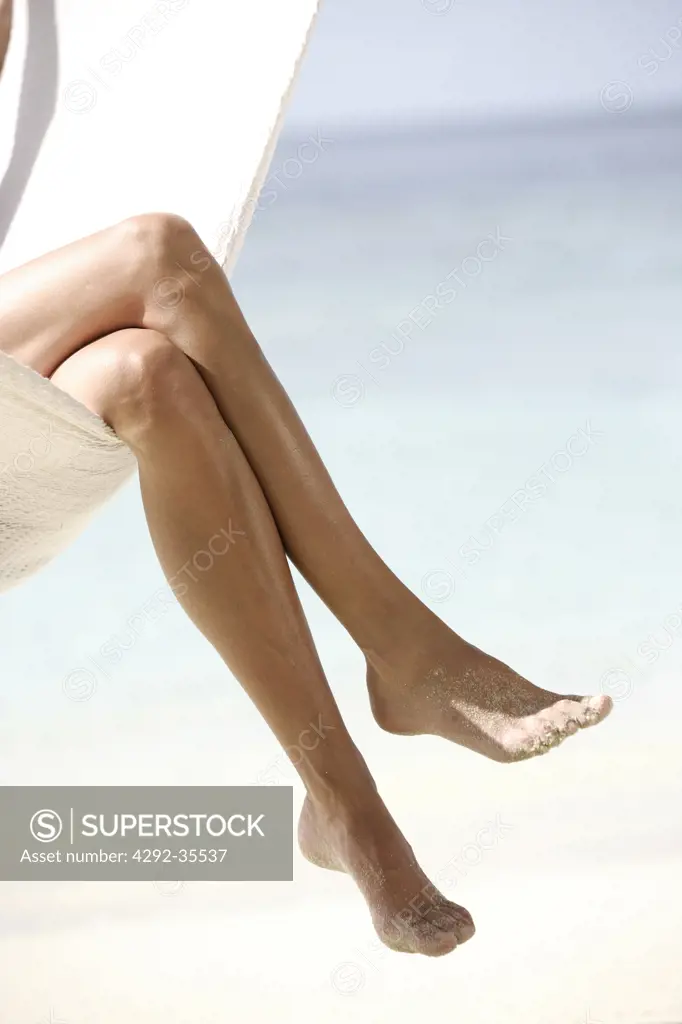Maldives, woman sitting in hammock, legs detail
