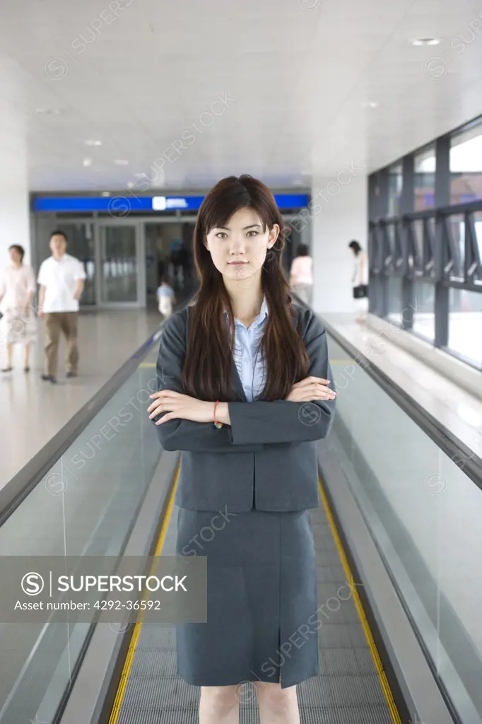 Chinese businesswoman on escalator at Shanghai airport