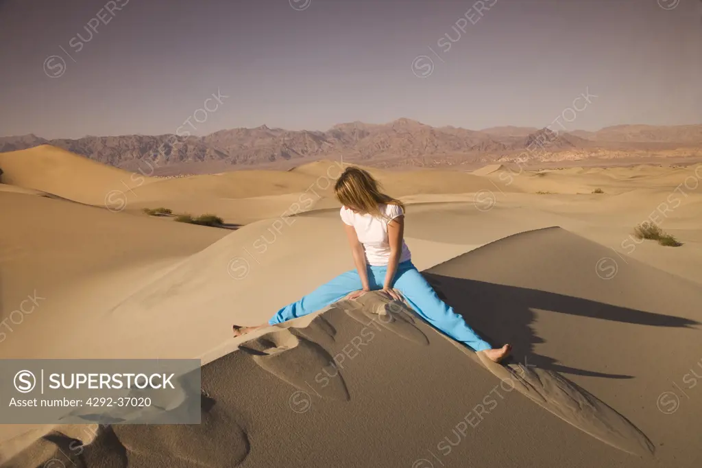 USA,California, Death Valley National Park, young woman sitting on dune