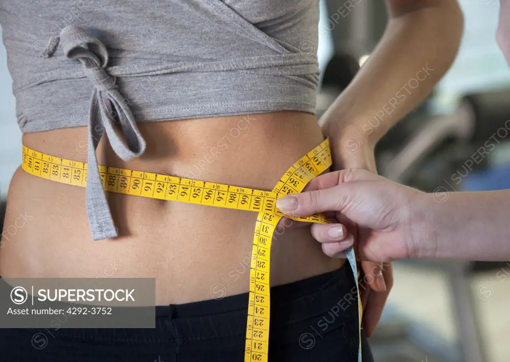 Woman holding tape measure around waist