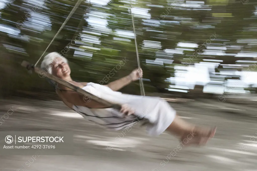 Maldives, Ari Atoll, senior woman swinging on hammock