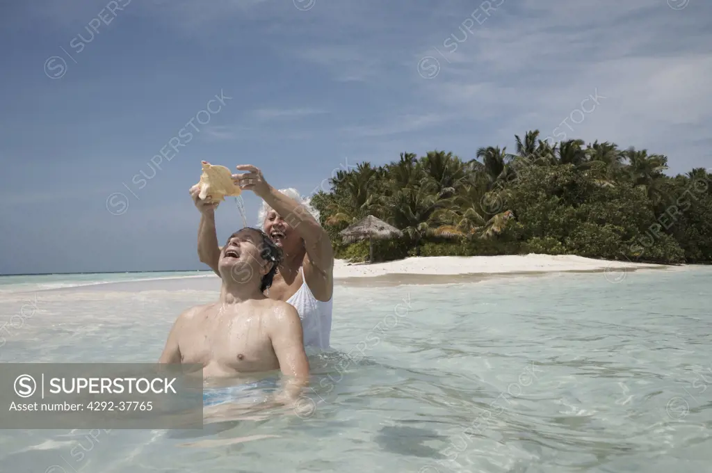 Maldives, Ari Atoll, senior couple holding a shell