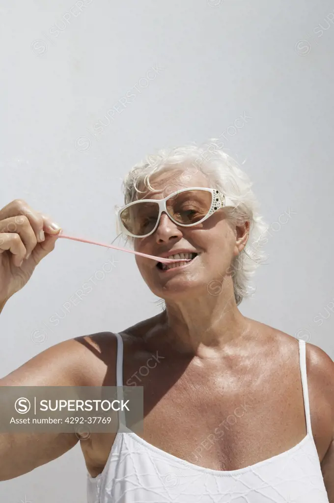 Senior woman pulling bubble gum