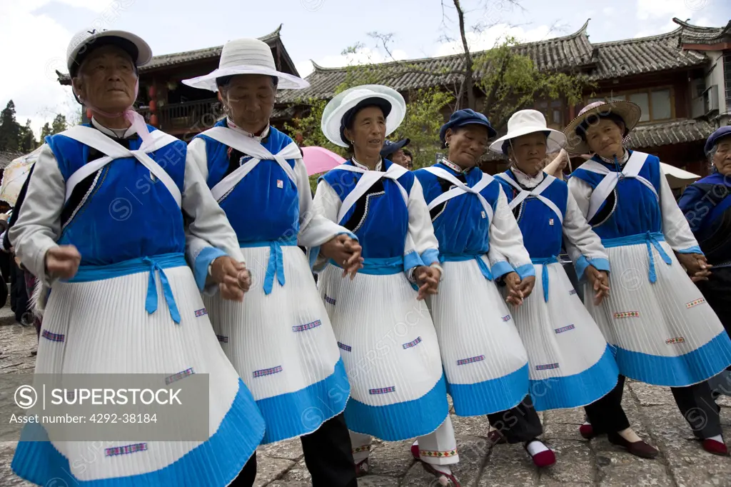 China, Yunnan Province, Lijiang, The Old Town. Naxi minority women dancing in Sifang Square