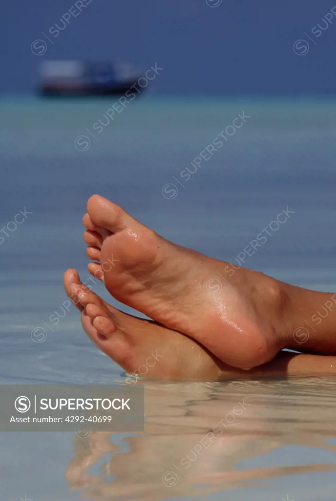 Maldives, Feet of a woman relaxing in the water