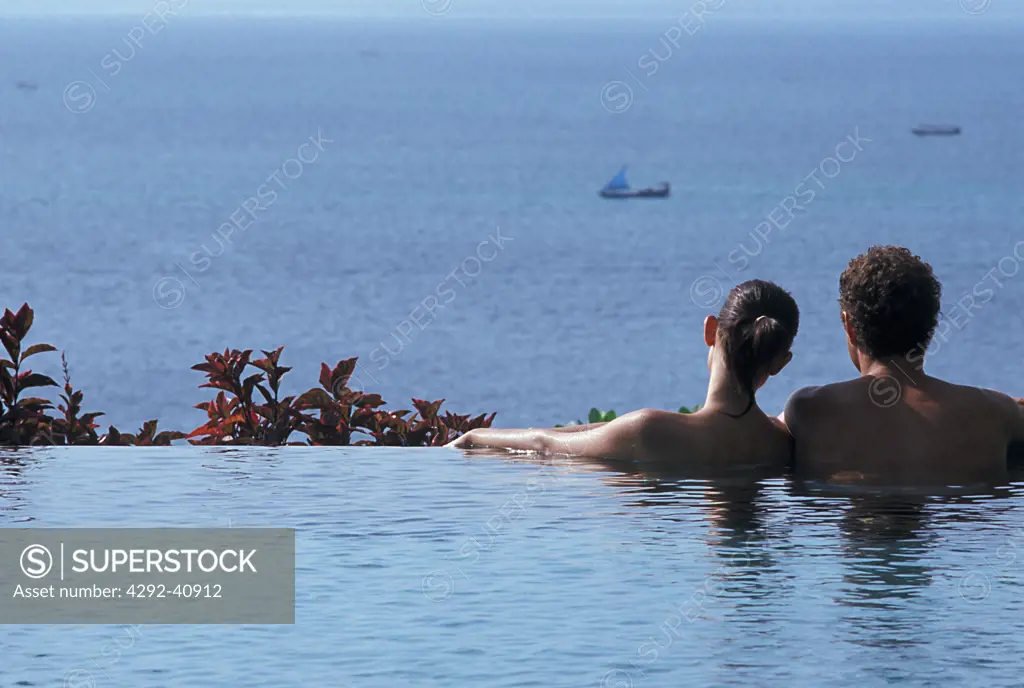 Couple in a pool looking at the sea