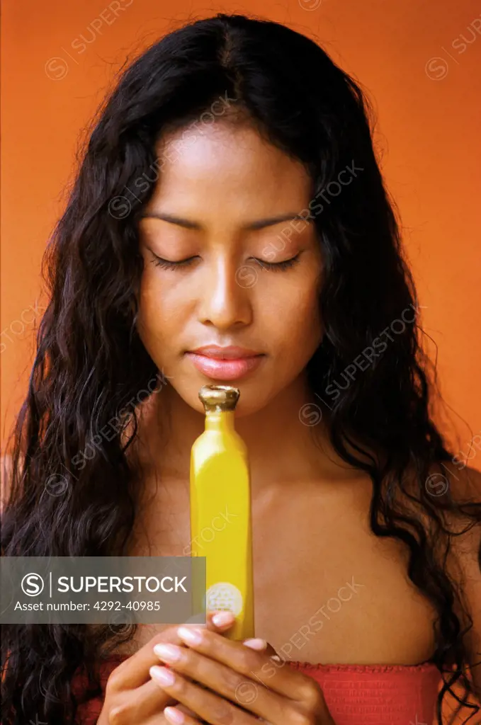 Young woman smelling at little bottle