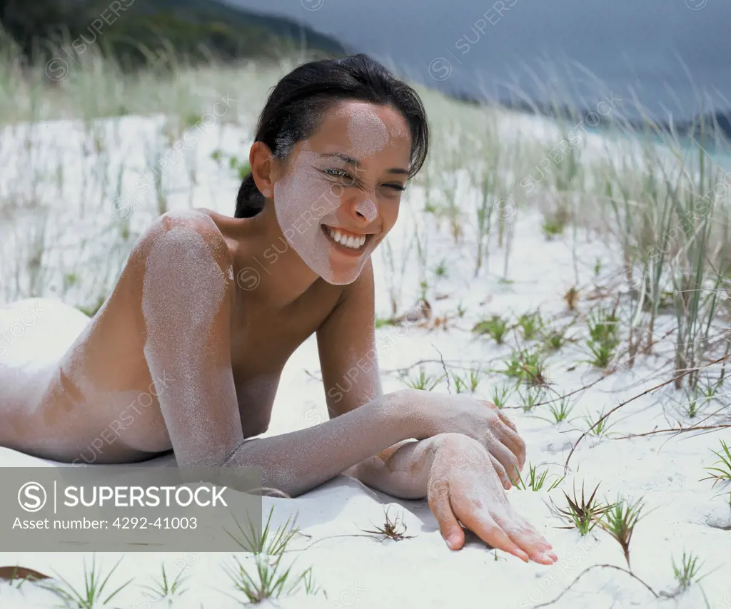 Young woman covered with sand