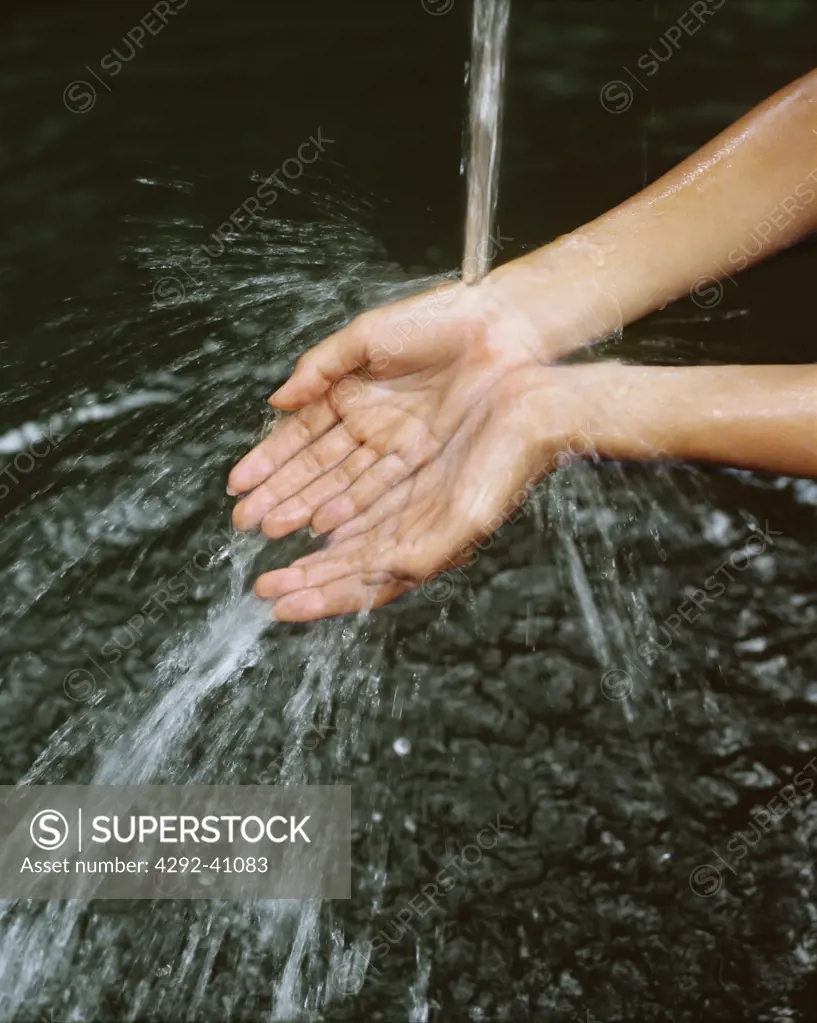 Close up of woman's hands under stream of water