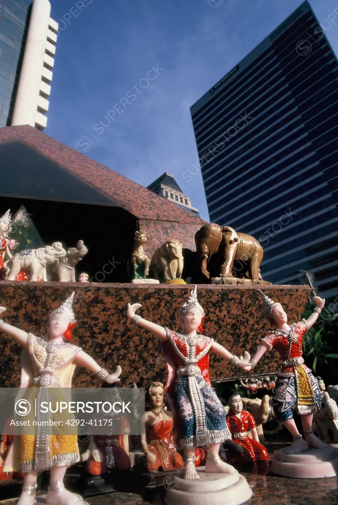 A contemporary spirit house with traditional offerings in front of a bank building in Sathorn Road, Bangkok, Thailand