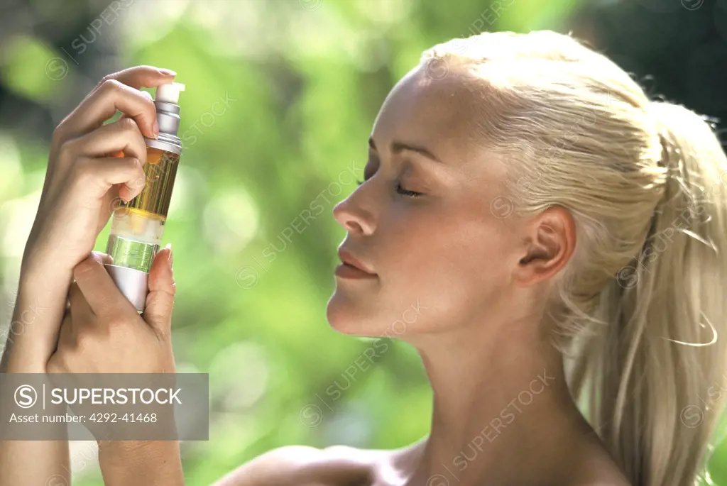 Woman refreshing herself with body spray