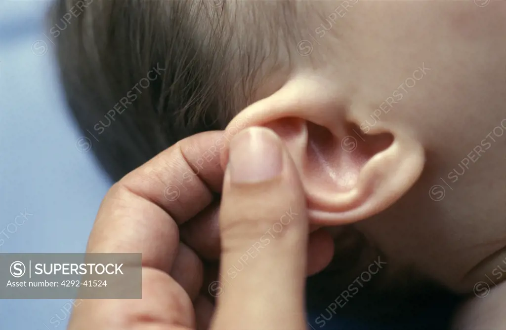Fingers massaging baby's ear