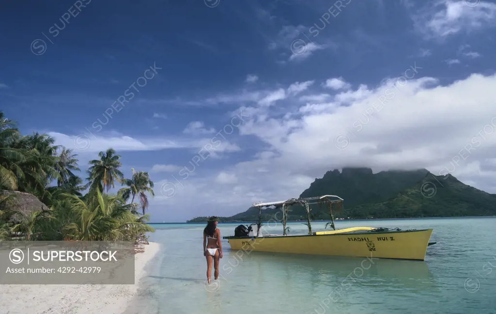 French Polynesia, Bora Bora. Woman walking in shallow water