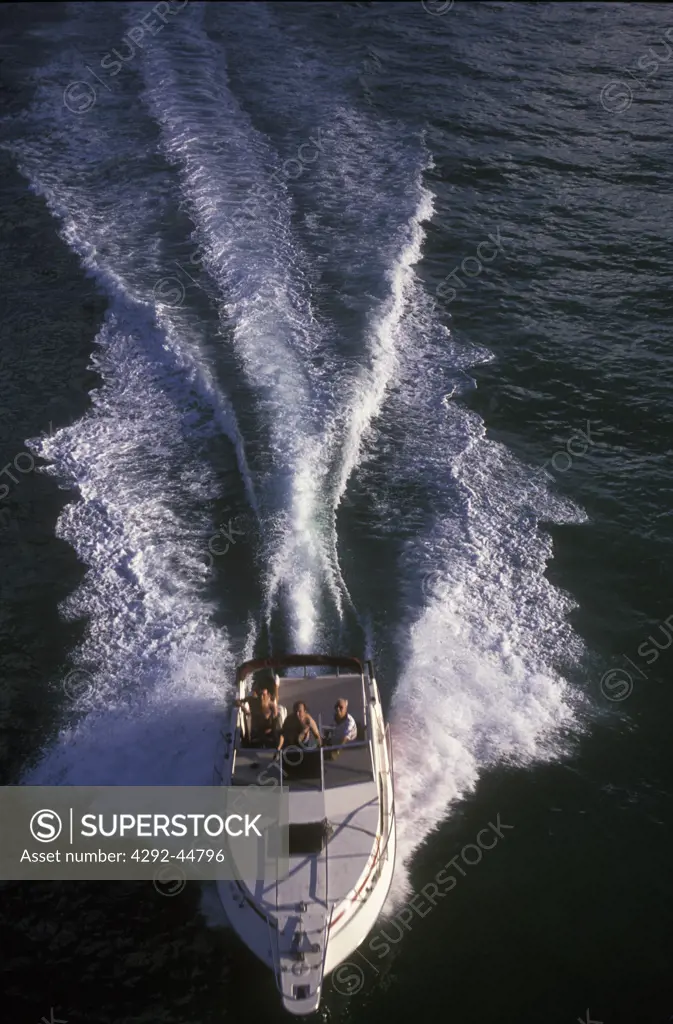 Aerial view of a boat speeding across water surface