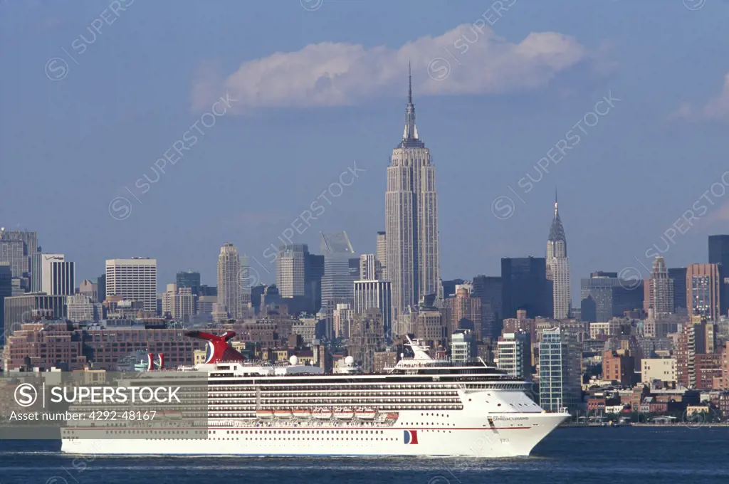 Usa, New York. Cruise ship sailing into city harbour with NY skyline