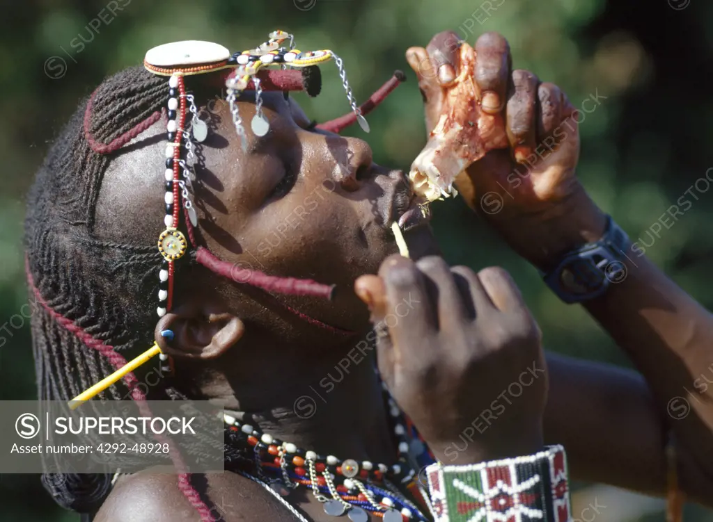 Africa, Kenya, Masai tribe, morani(warrior) ceremony, man eating raw meat
